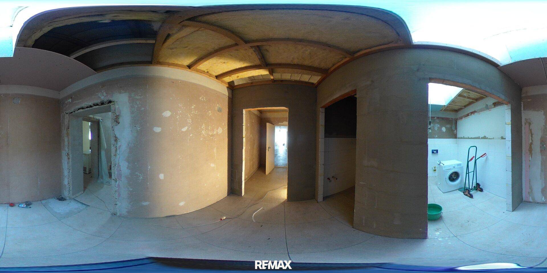 Hauswirtschaftsraum im Rohbau mit Waschmaschine und unfertigen Wänden, bereit für den Ausbau.