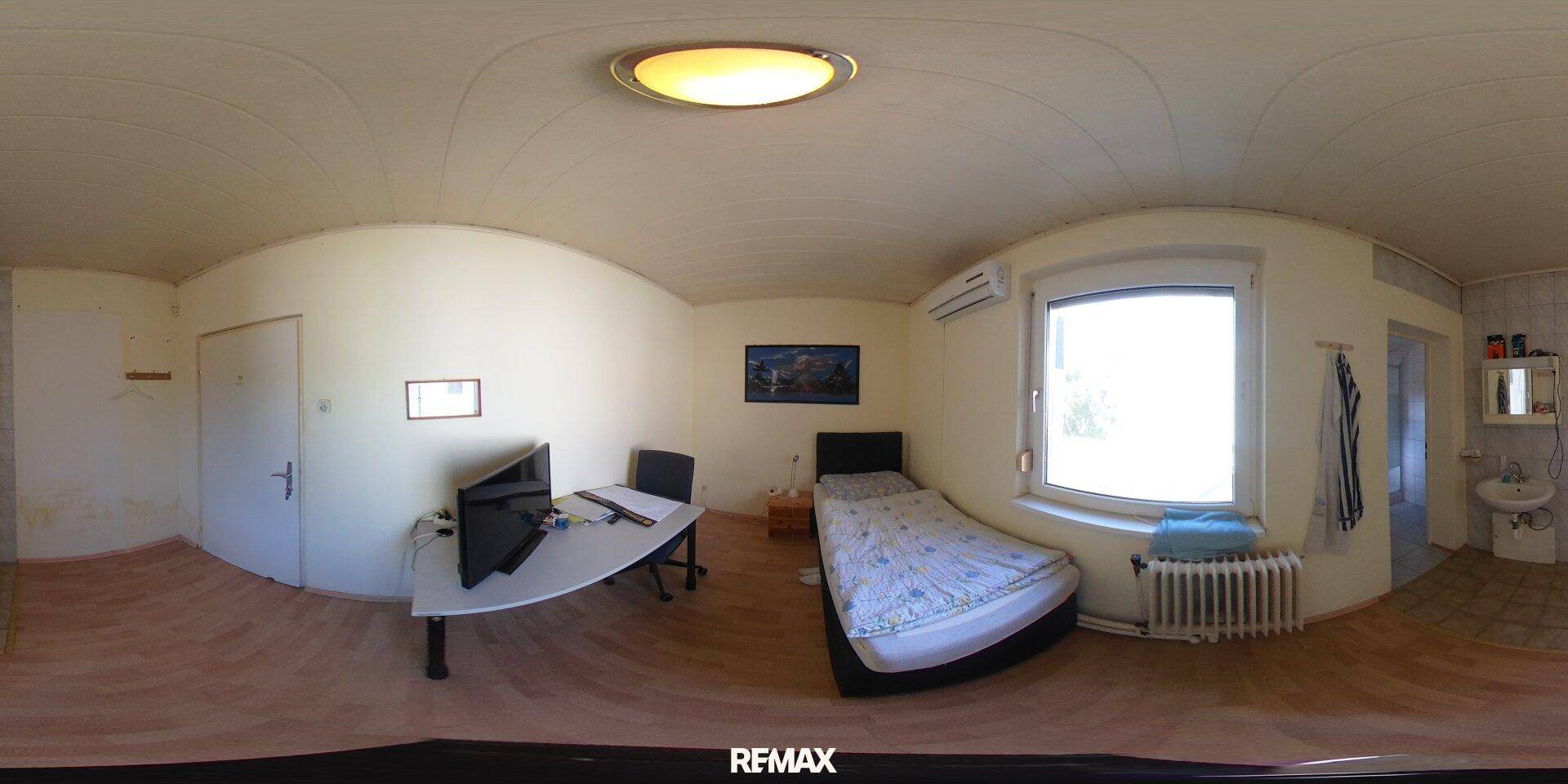 Helles Schlafzimmer mit Einzelbett, Schreibtisch und Klimaanlage, ideal als Gästezimmer.