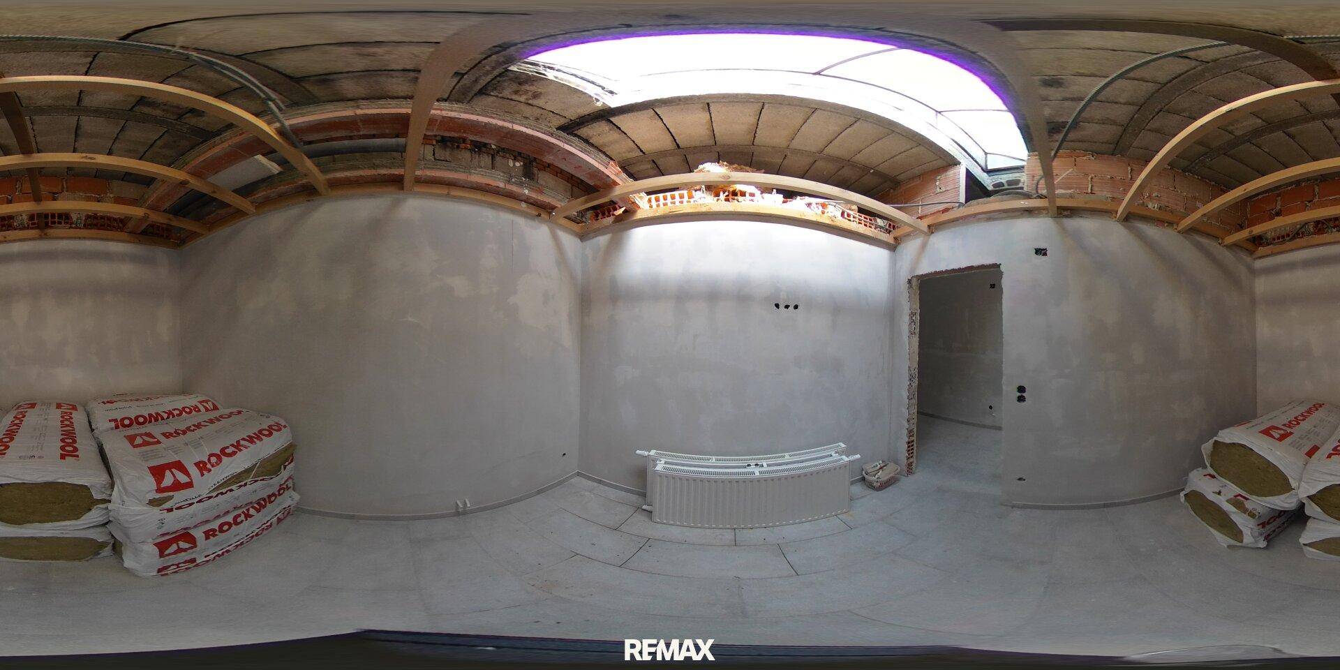 Dachgeschoss im Rohbau mit sichtbarer Holzkonstruktion und Dämmmaterial, bereit für den Ausbau.