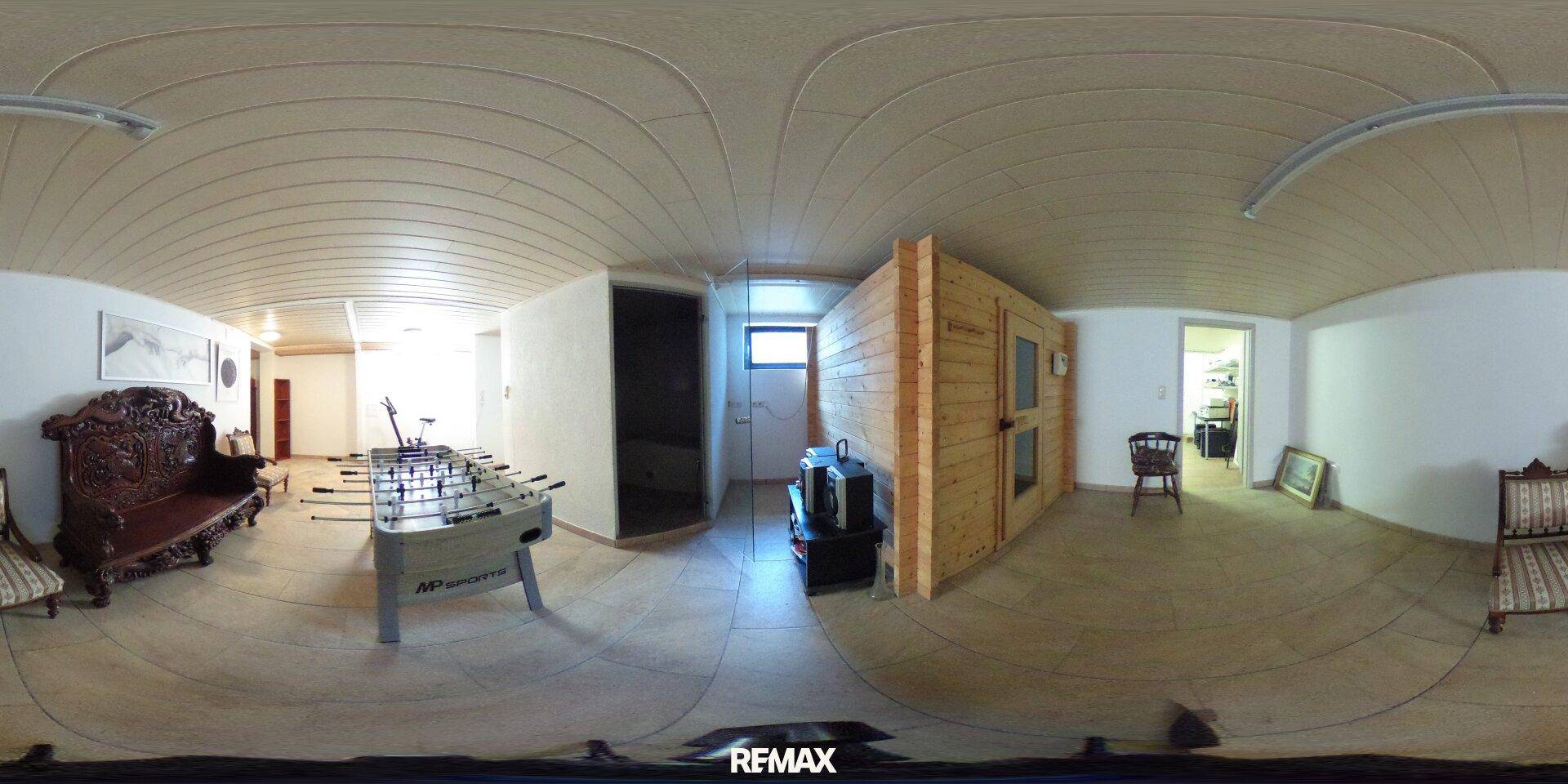 Geräumiger Kellerraum mit Sauna, Tischfußball und gemütlichen Sitzgelegenheiten.