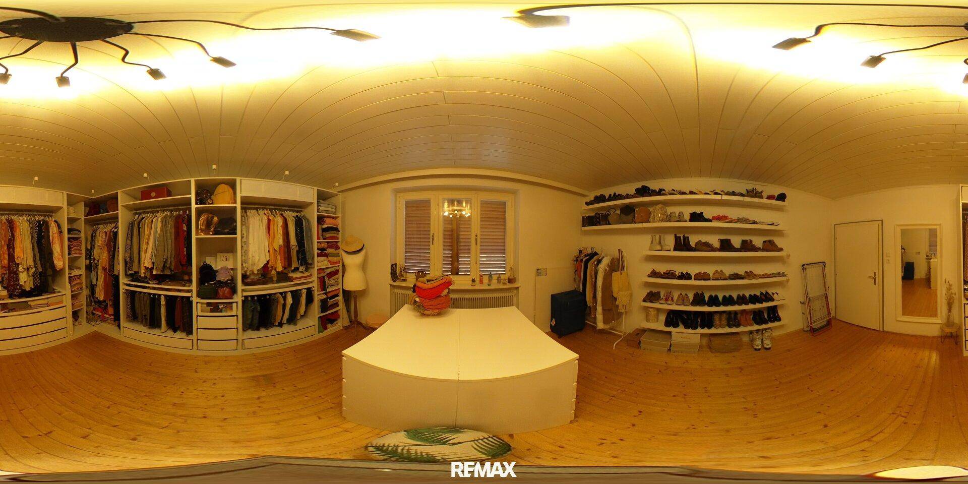 Großzügiger begehbarer Kleiderschrank mit umfangreichen Einbauschränken und Regalen.