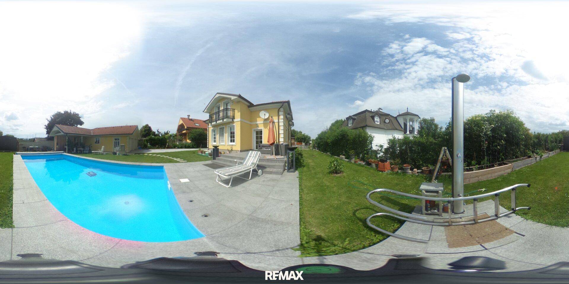 Großer Außenbereich mit Swimmingpool, Liegestühlen und gepflegtem Rasen vor dem Haus.
