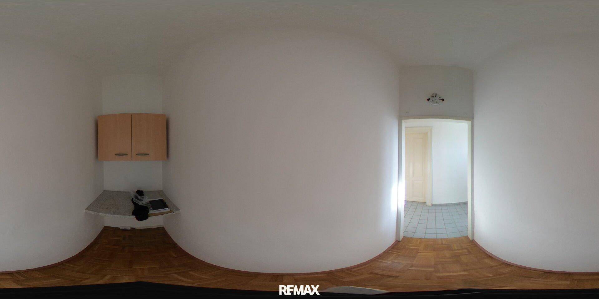 Panorama eines kleinen Nischenbereichs mit Holzschränken und einer Arbeitsplatte.