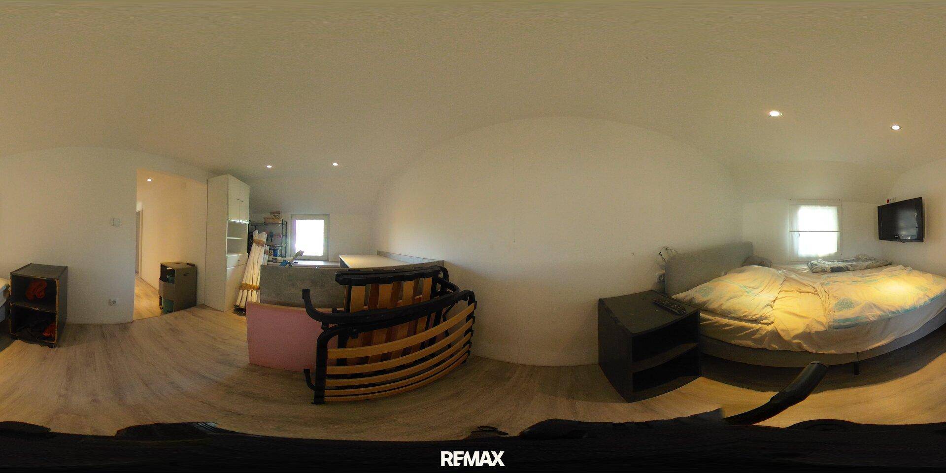 Schlafzimmer mit Doppelbett, Nachttisch und hellem Laminatboden in einer 360-Grad-Ansicht.