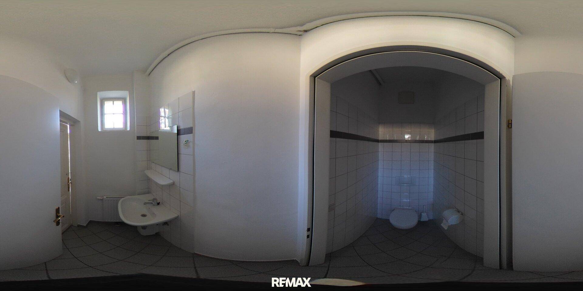 360-Grad-Innenansicht einer Toilette mit weißen Fliesen, WC, Waschbecken und einem kleinen Fenster.