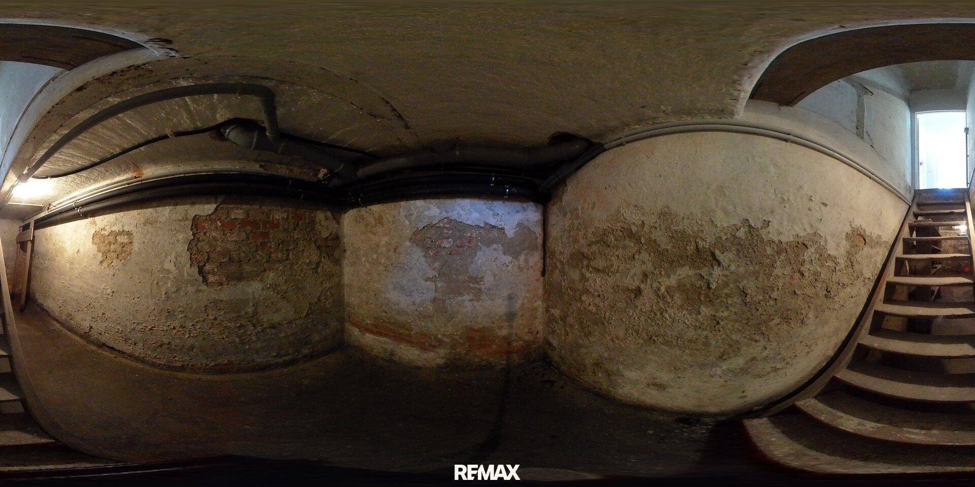 360-Grad-Innenansicht eines Kellers mit rauen Wänden, sichtbaren Rohren und einer Treppe.