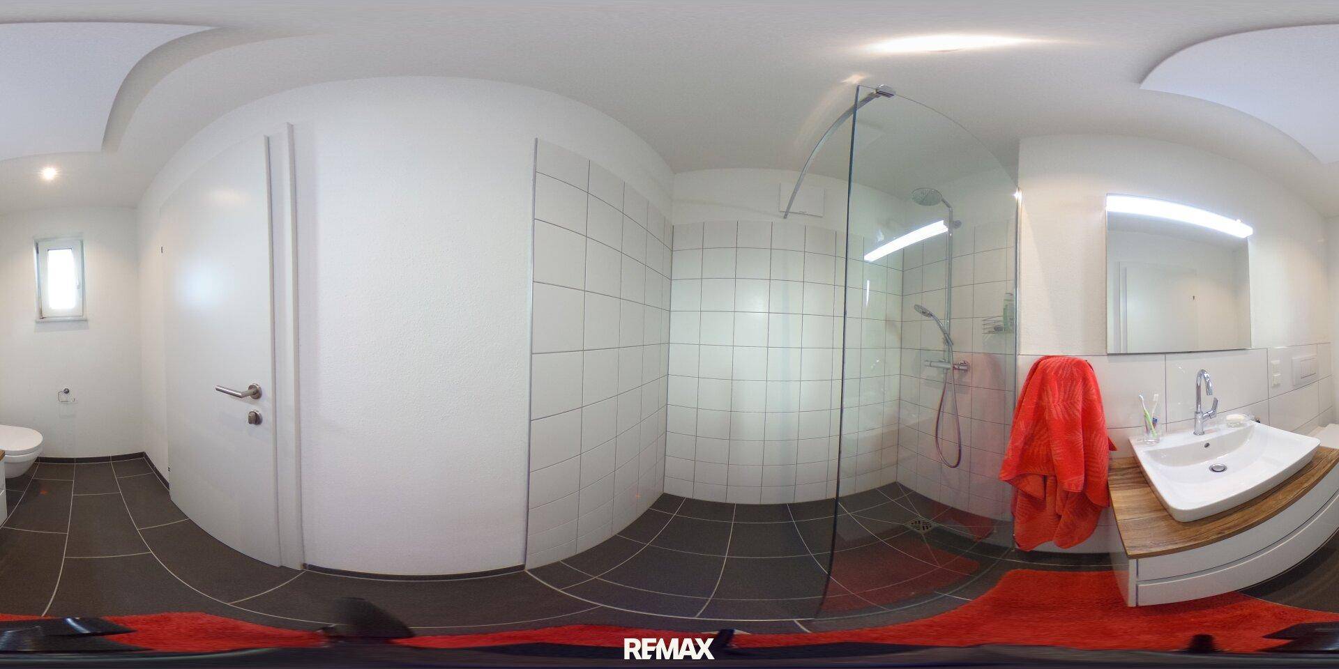 Modernes Badezimmer mit begehbarer Dusche, Einzelwaschbecken und dunklen Bodenfliesen.