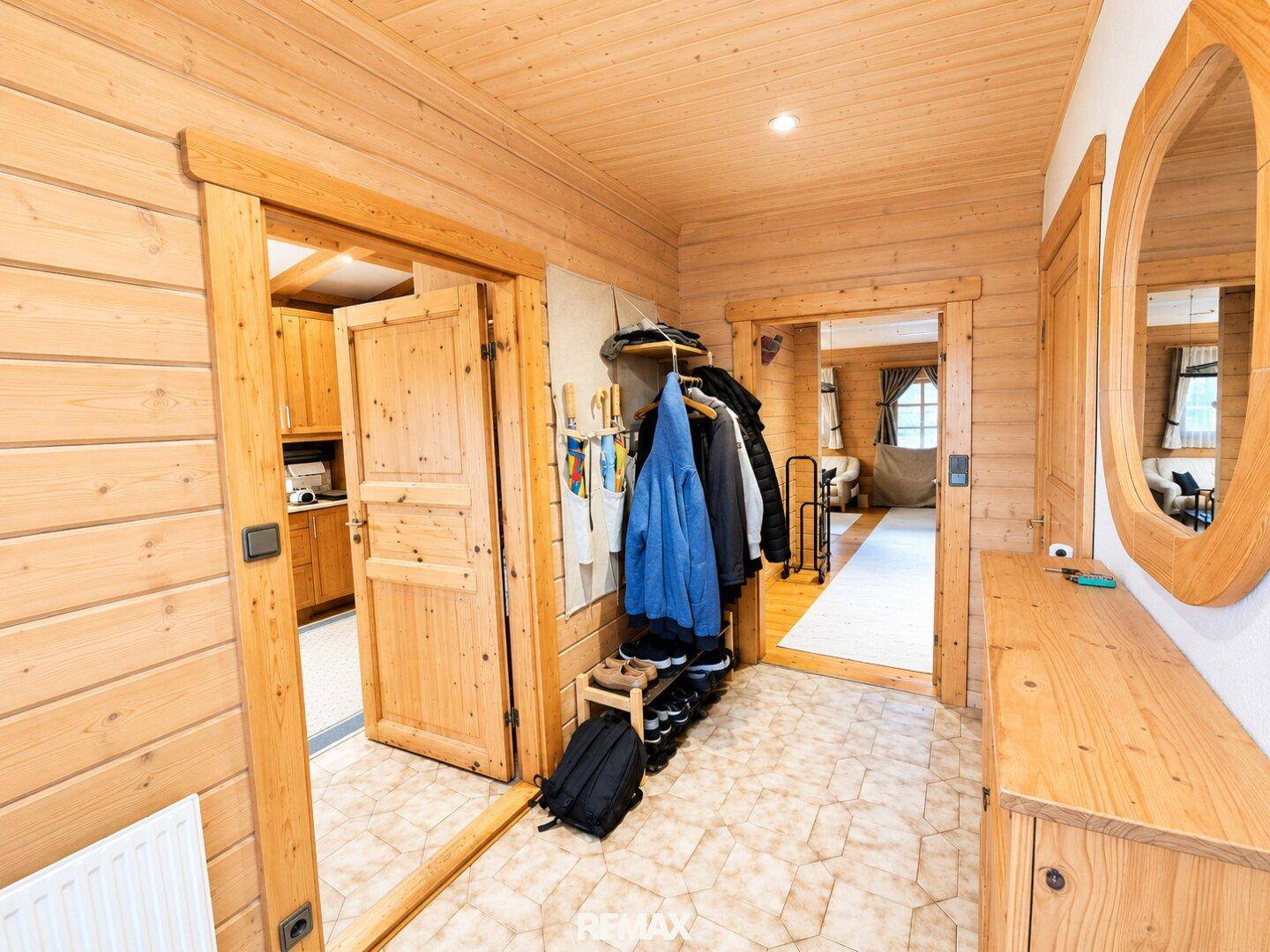 Gemütlicher Eingangsbereich mit Holzvertäfelung, Garderobe und Spiegel.