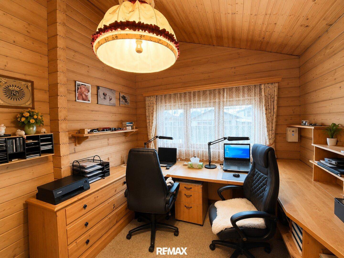Helles Arbeitszimmer mit Holzvertäfelung, zwei Schreibtischen und Stauraum.