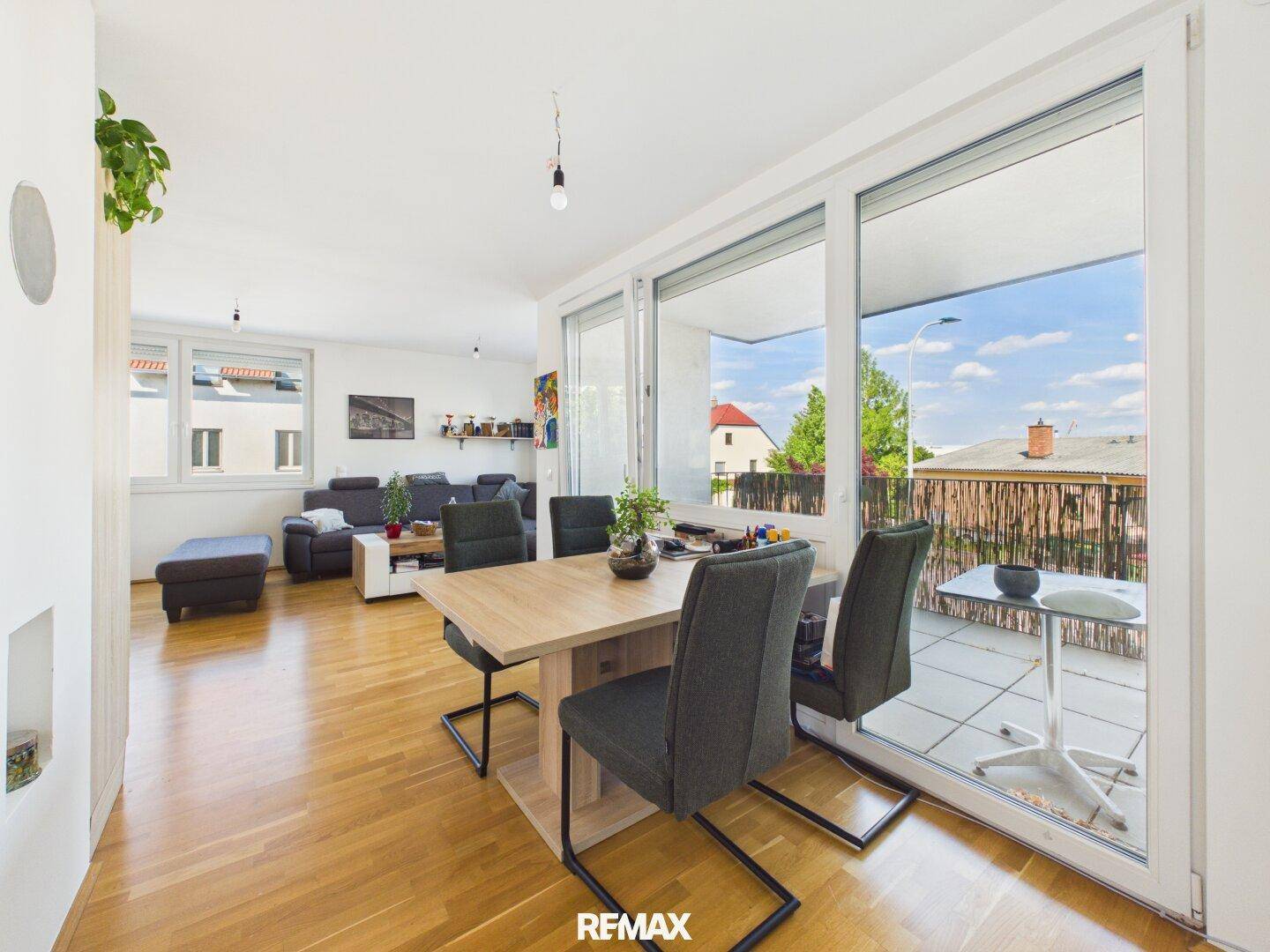 Essbereich mit großem Fenster und direktem Zugang zum Außenbalkon.