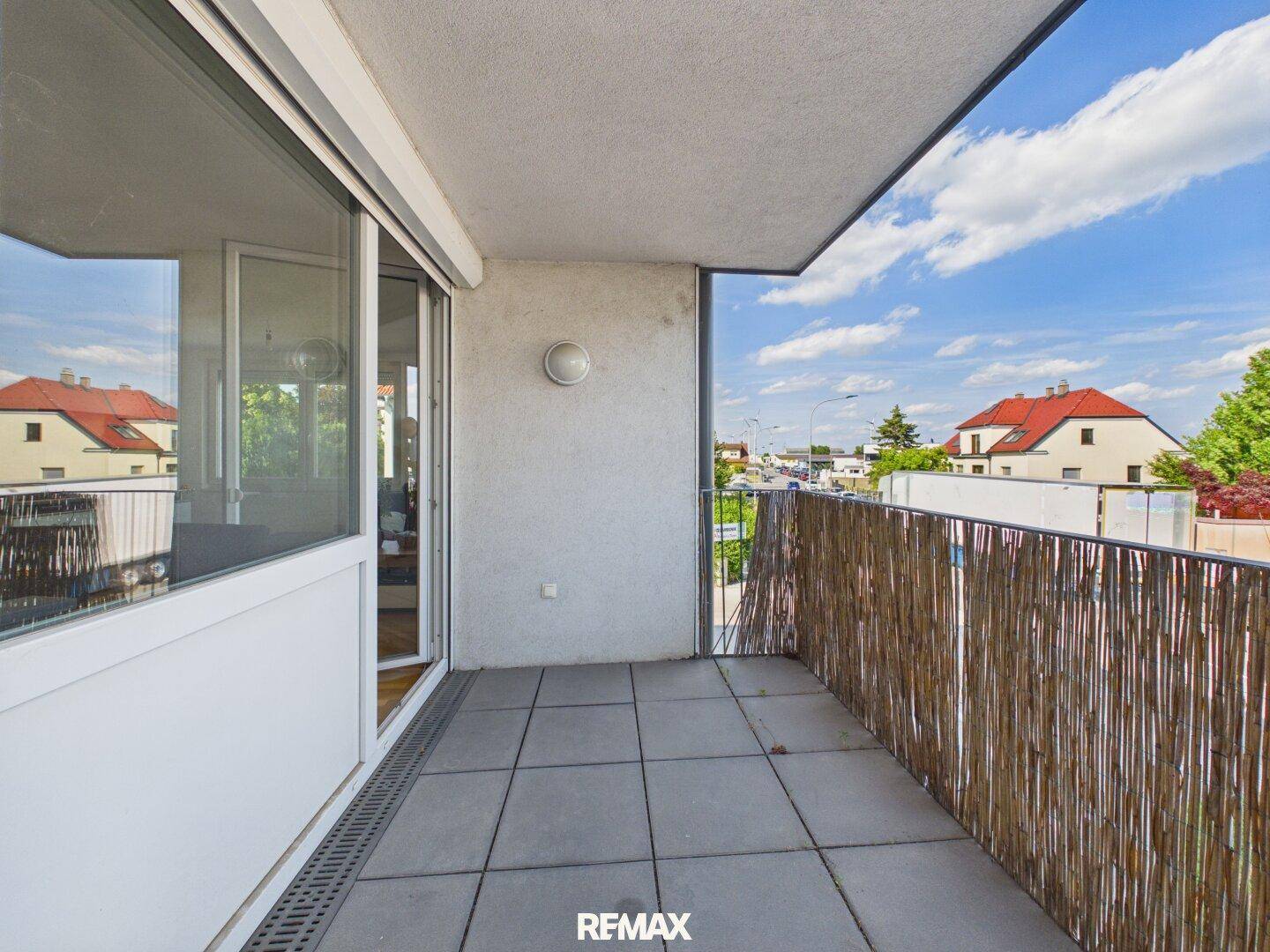 Geräumiger Balkon mit Fliesenboden und weitem Blick über die Nachbarschaft.