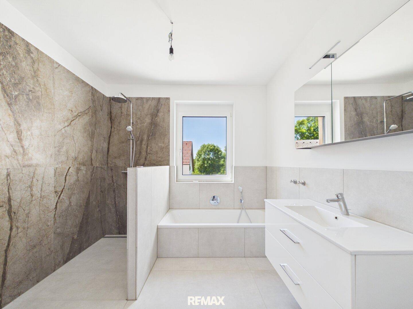 Modernes Badezimmer mit Badewanne, begehbarer Dusche und Fenster.