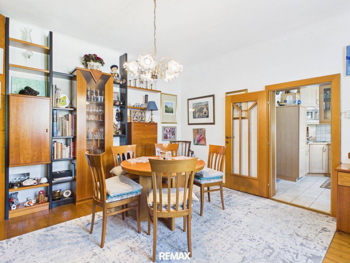 Essbereich mit rustikalem Holztisch, passenden Stühlen und einem großen Bücherregal.