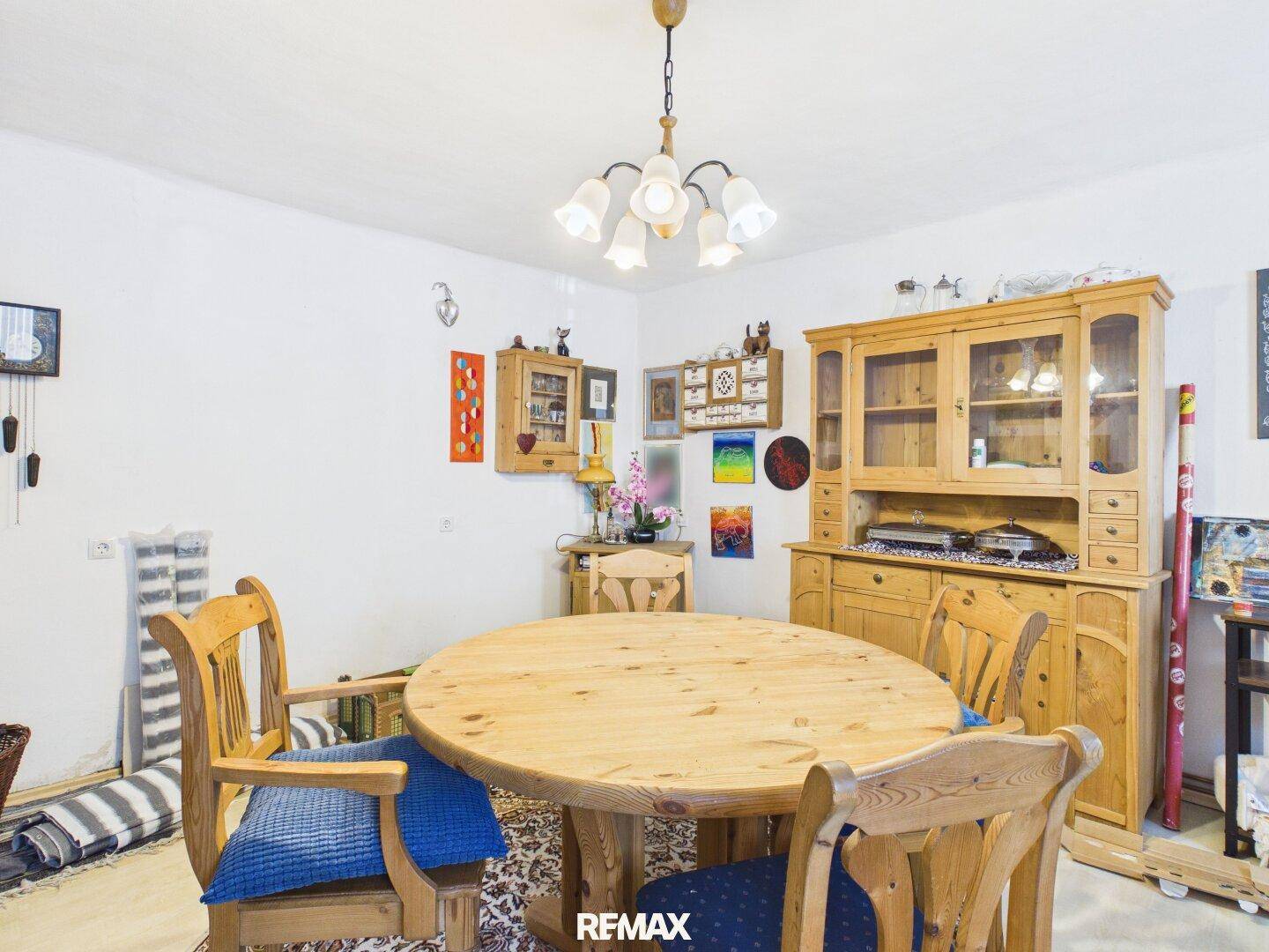 Rustikaler Essbereich mit massivem Holztisch, passenden Stühlen und traditionellen Möbeln.