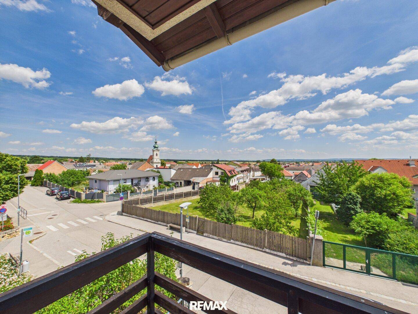 Weitläufiger Ausblick vom Balkon über die Dächer der Stadt und die umliegende Landschaft.