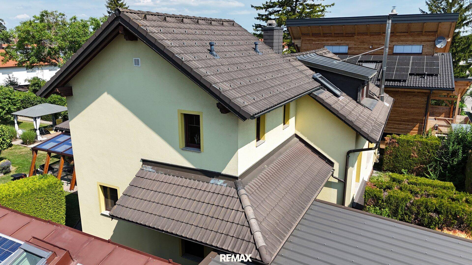 Seitenansicht des Hauses mit traditionellem Ziegeldach und mehreren Fenstern.