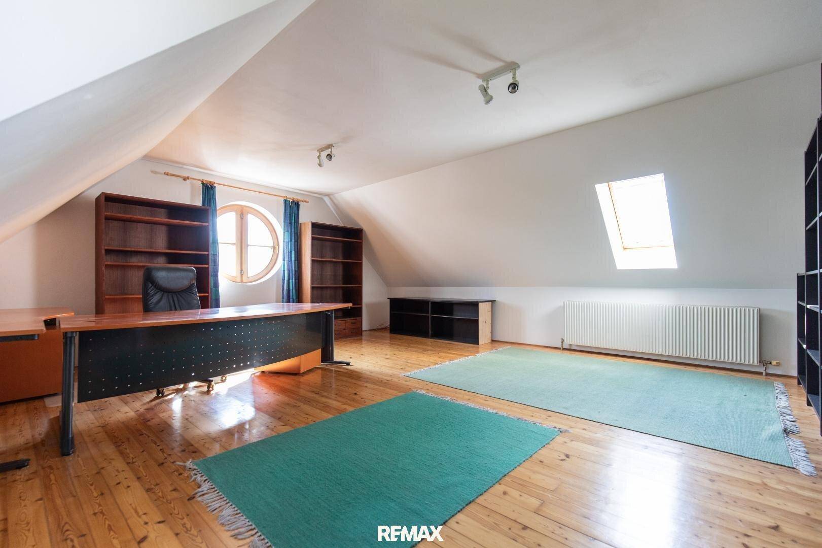 Großes Dachzimmer, ideal als Büro, mit Holzboden und Dachfenster.