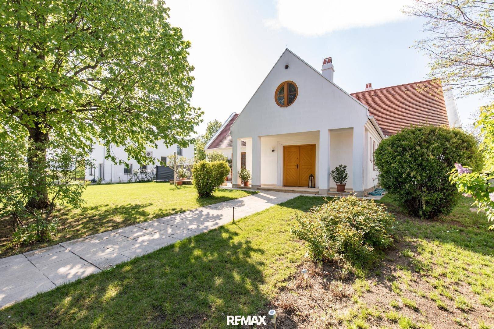 Vorderansicht des Hauses mit gepflegtem Vorgarten und Zugangsweg.
