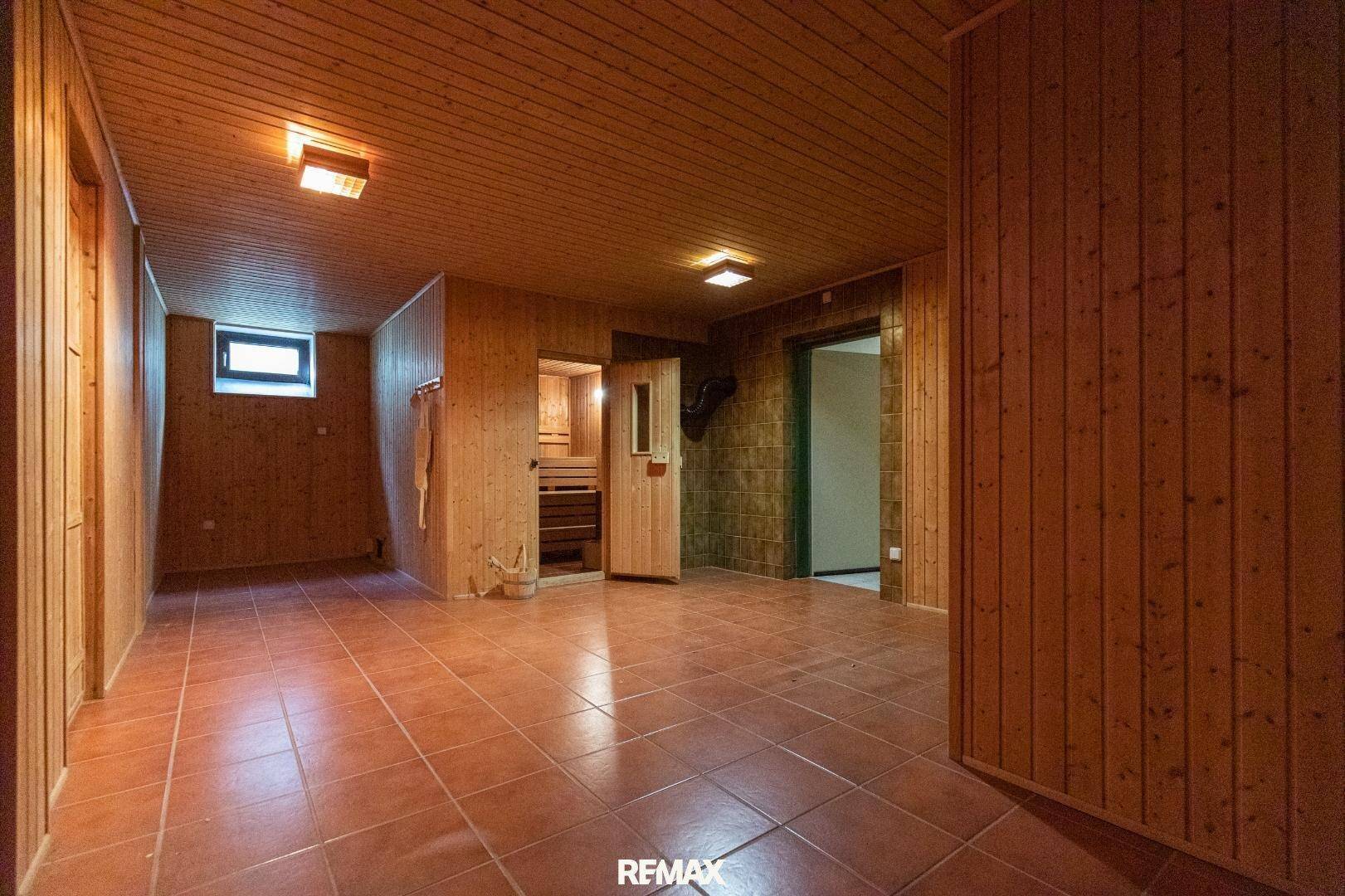 Großer Kellerraum mit Holzverkleidung und Zugang zur Sauna, ideal für Wellness.