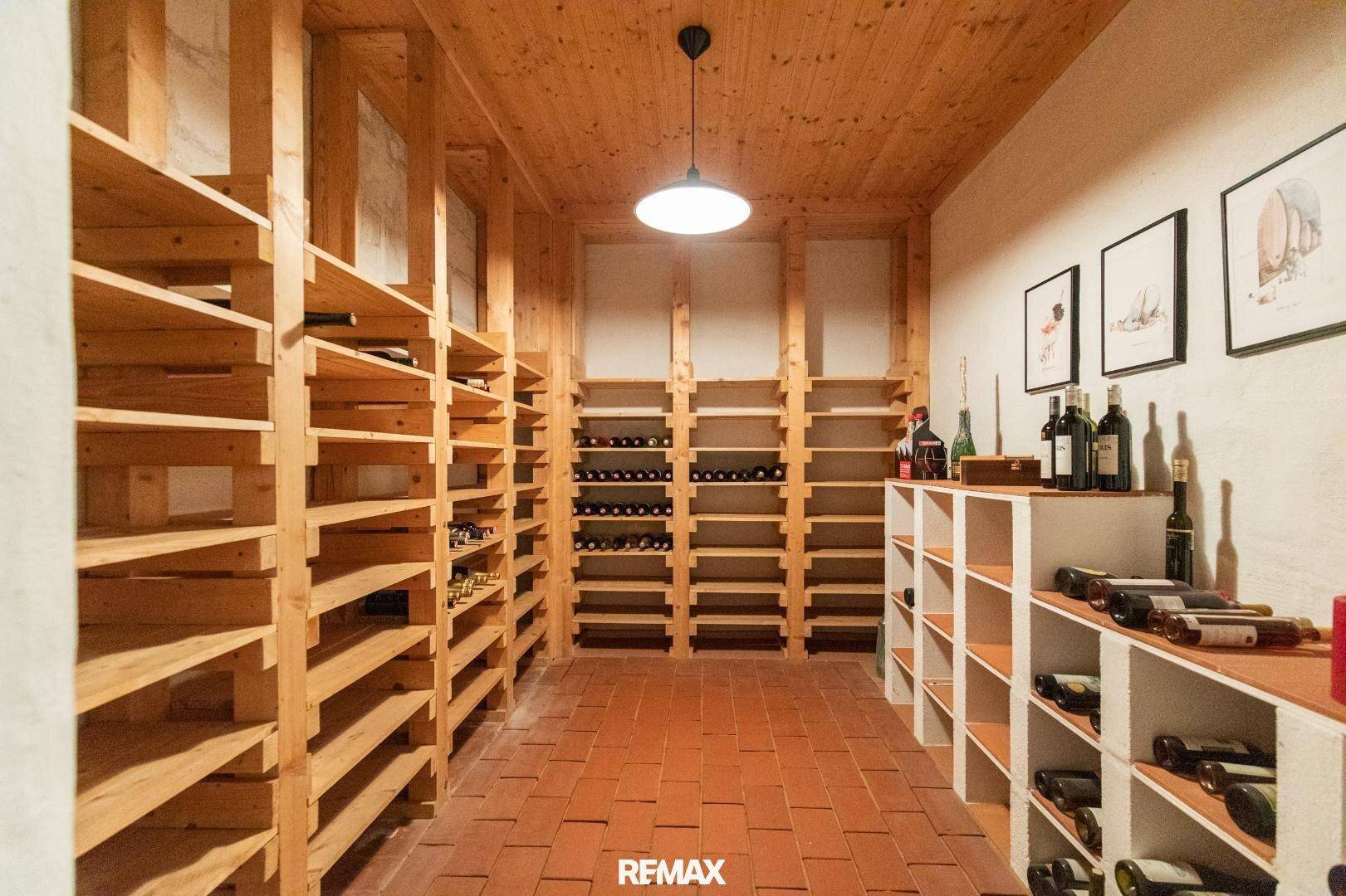 Geräumiger Weinkeller mit Holzregalen und Terrakottafliesen, ideal zur Lagerung.