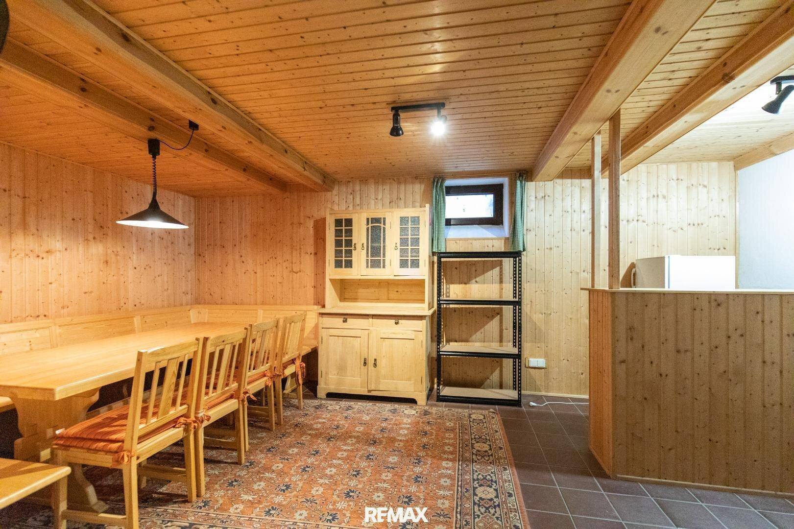 Gemütlicher Essbereich im alpinen Stil mit Holztäfelung, Holzbalken und rustikalen Möbeln.