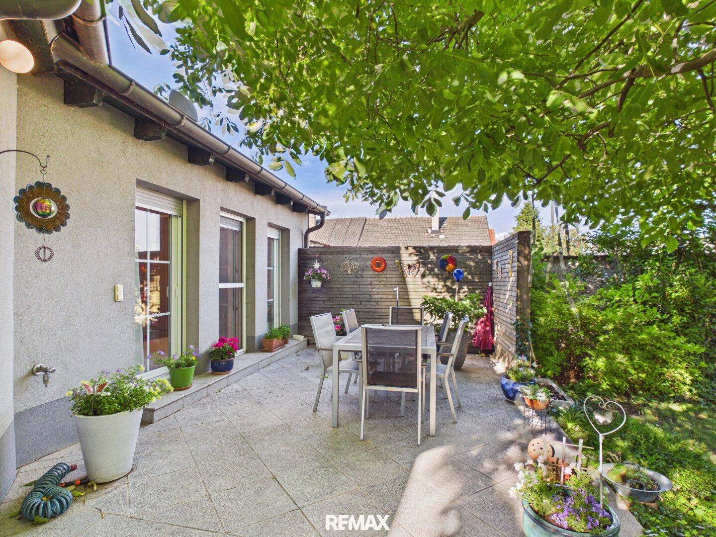 Gemütliche Terrasse mit Essbereich und Blick in den gepflegten Garten.
