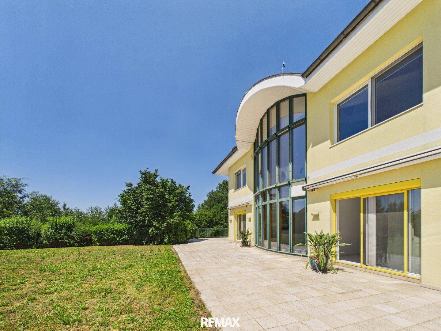 Weitläufige Terrasse neben dem Haus mit viel Platz für Outdoor-Aktivitäten.