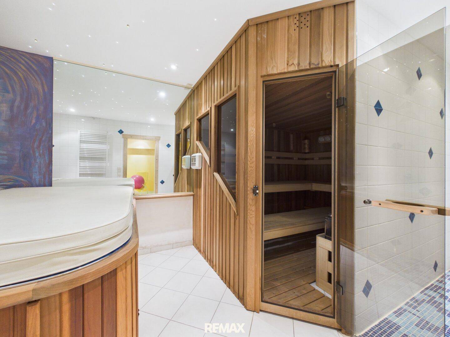 Wellnessbereich mit Sauna, Whirlpool und Duschbereich für Entspannung.