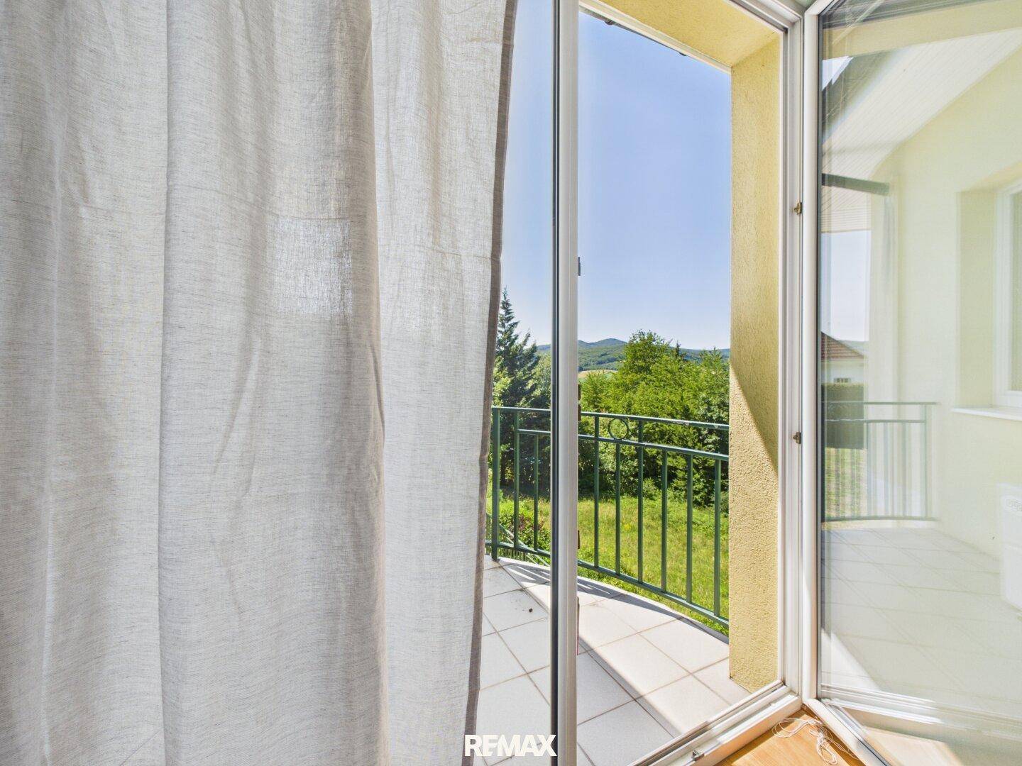 Kleiner Balkon mit schmiedeeisernem Geländer und weitem Blick über die Landschaft.