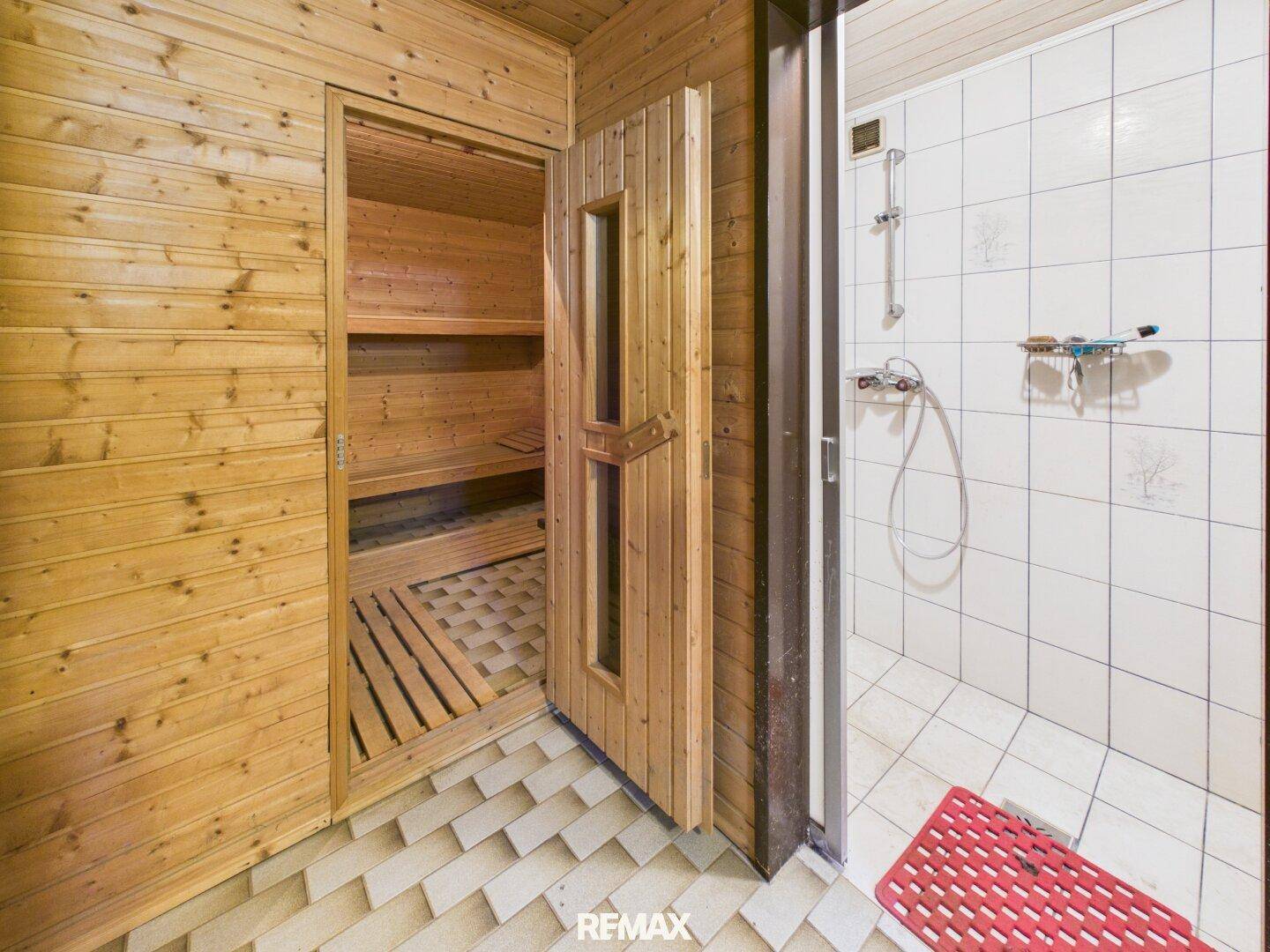 Private Sauna mit Holzverkleidung und angrenzendem Duschbereich für Entspannung.