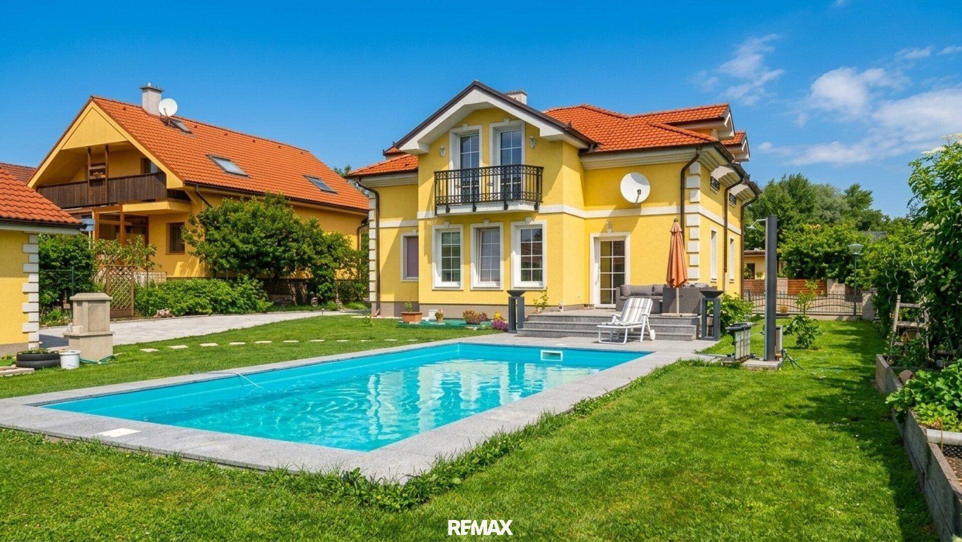 Hinterhof mit großem Swimmingpool, Rasenfläche und Terrasse am Haus.