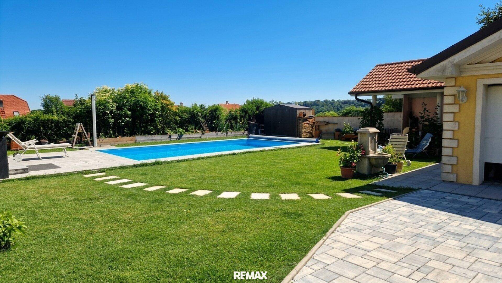 Weitläufiger Gartenbereich mit Pool, Liegestühlen und gepflastertem Weg.
