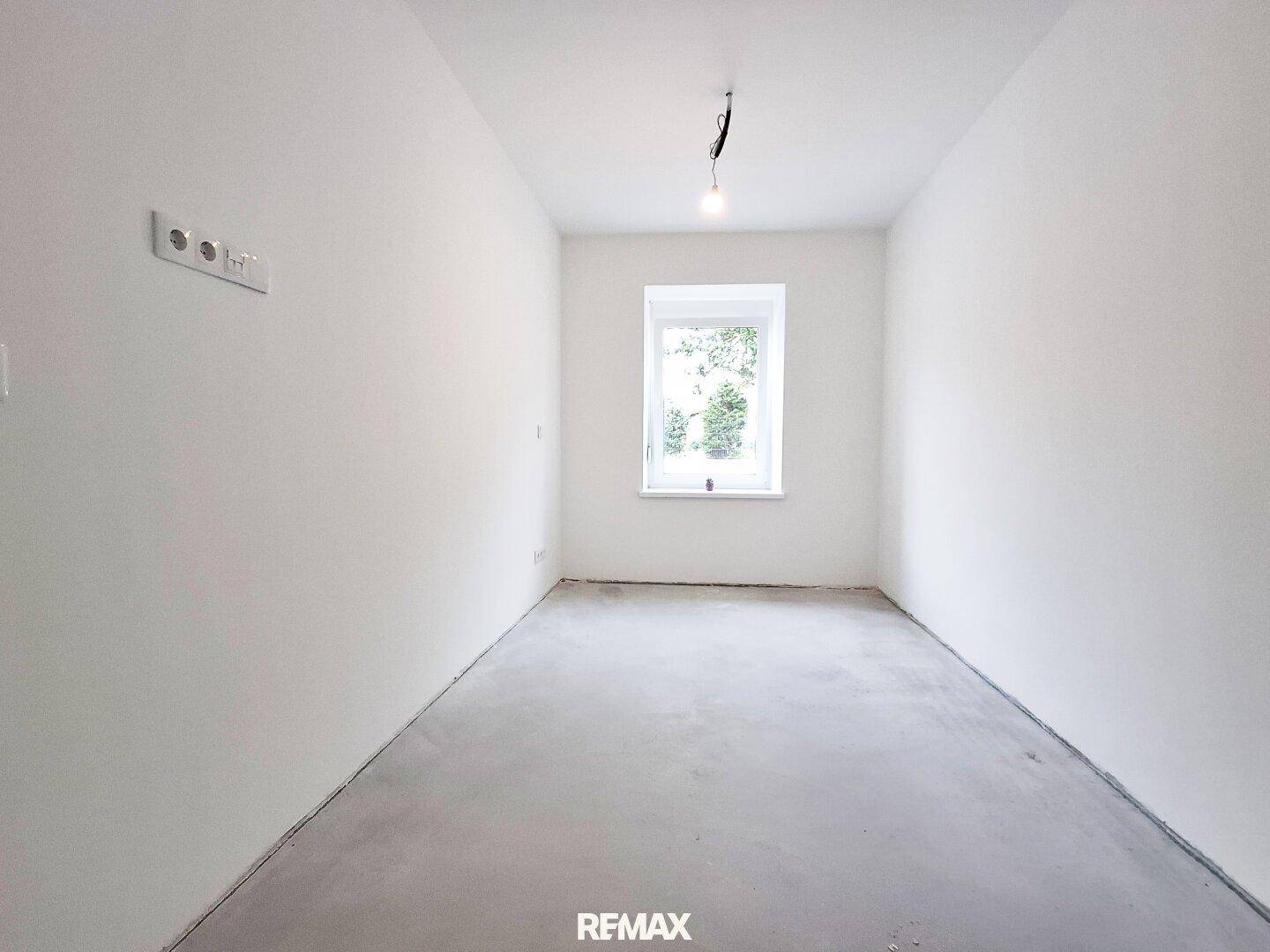 Heller, leerer Raum mit weißen Wänden und Betonboden, bereit für individuelle Gestaltung.
