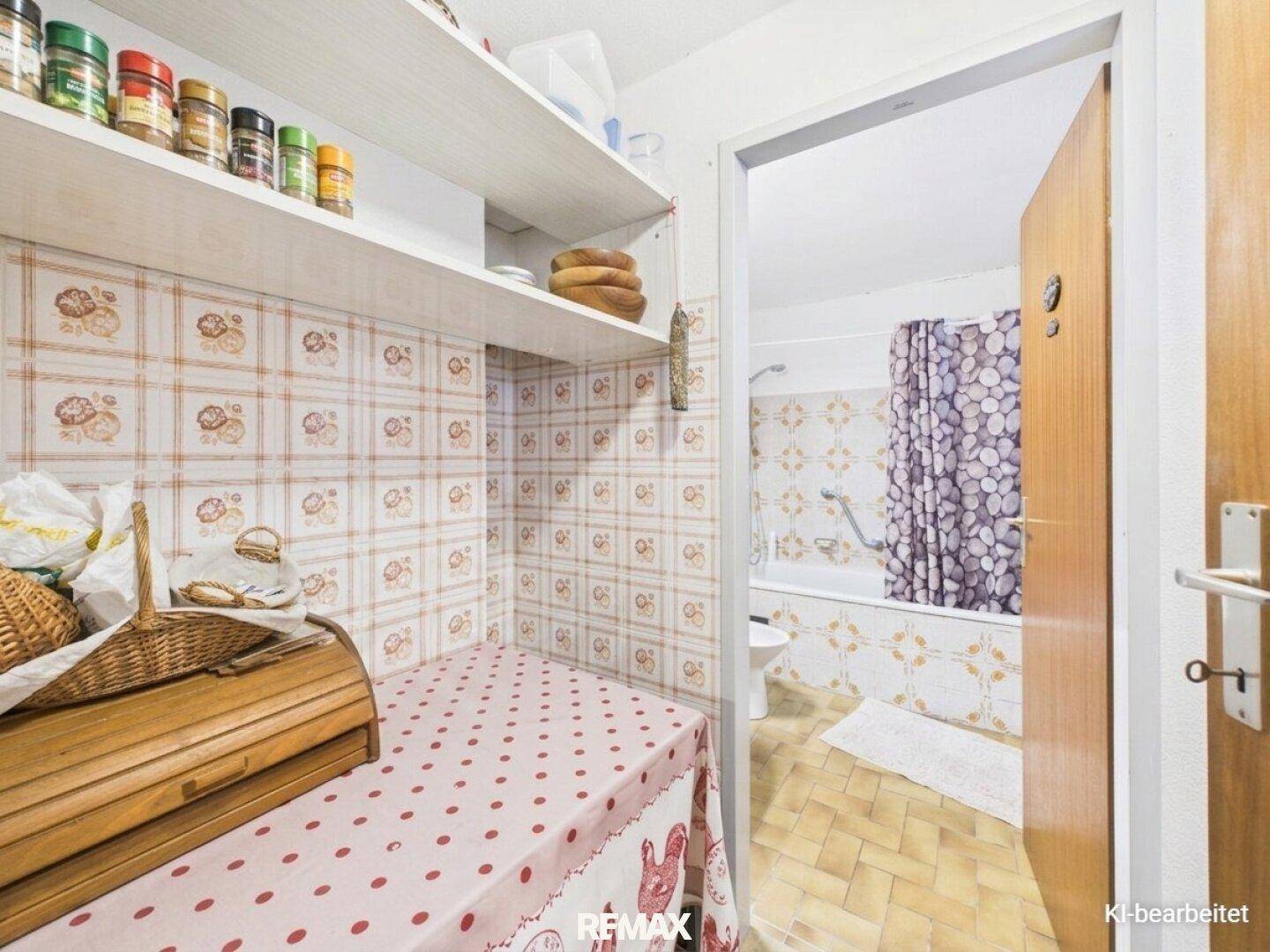 Praktischer Abstellraum mit Regalen und Zugang zu einem Badezimmer mit Badewanne.