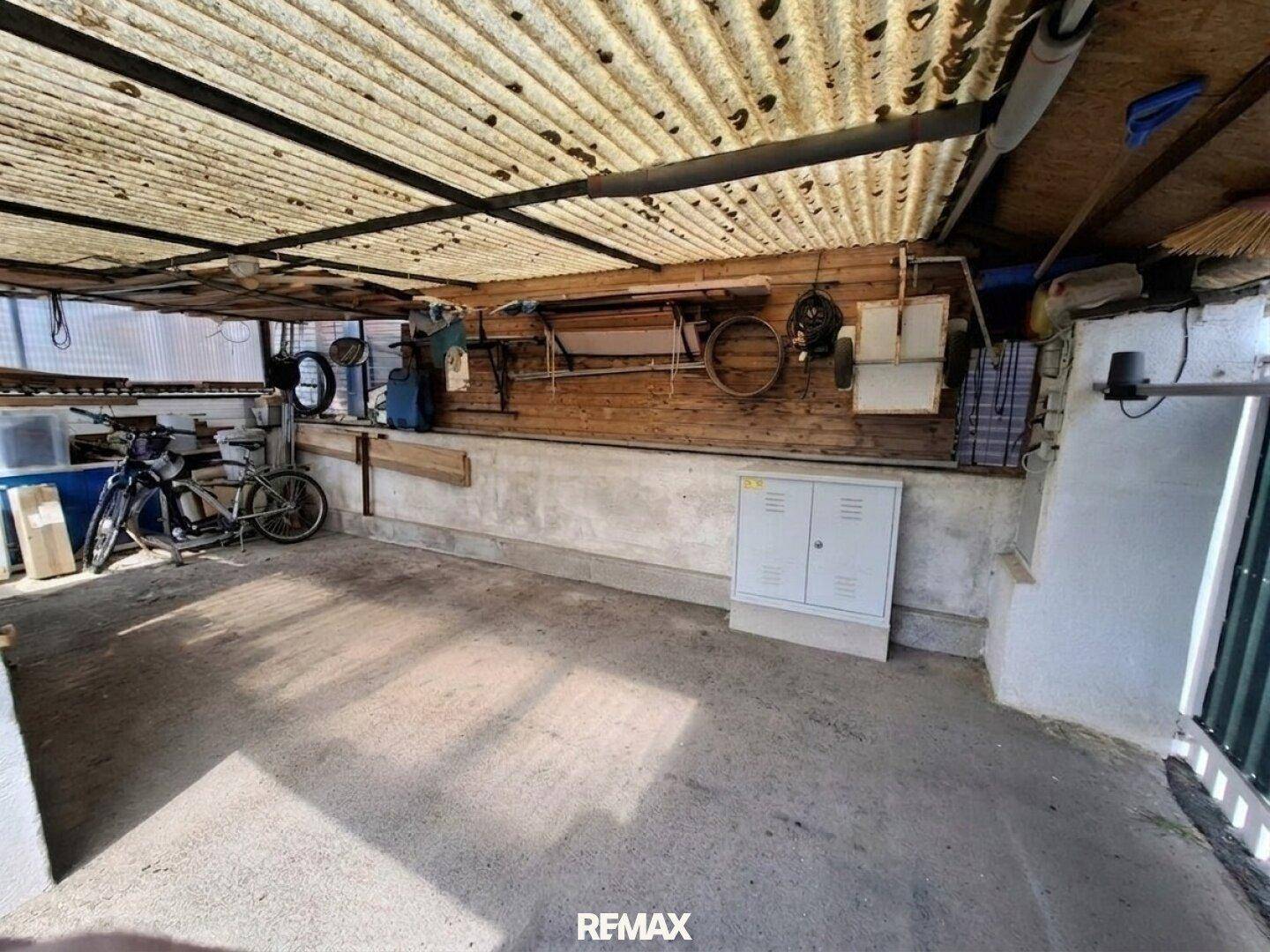 Überdachter Bereich, der als Carport oder Abstellfläche für Fahrräder und Geräte dient.