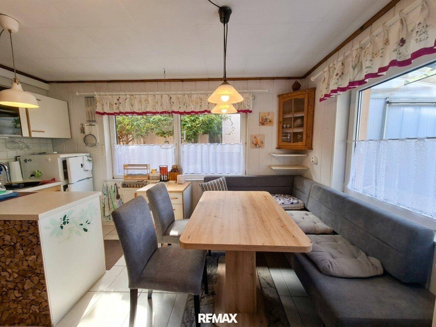 Essbereich mit Holztisch und Sitzbank, integriert in den offenen Wohnraum mit Fensterblick.