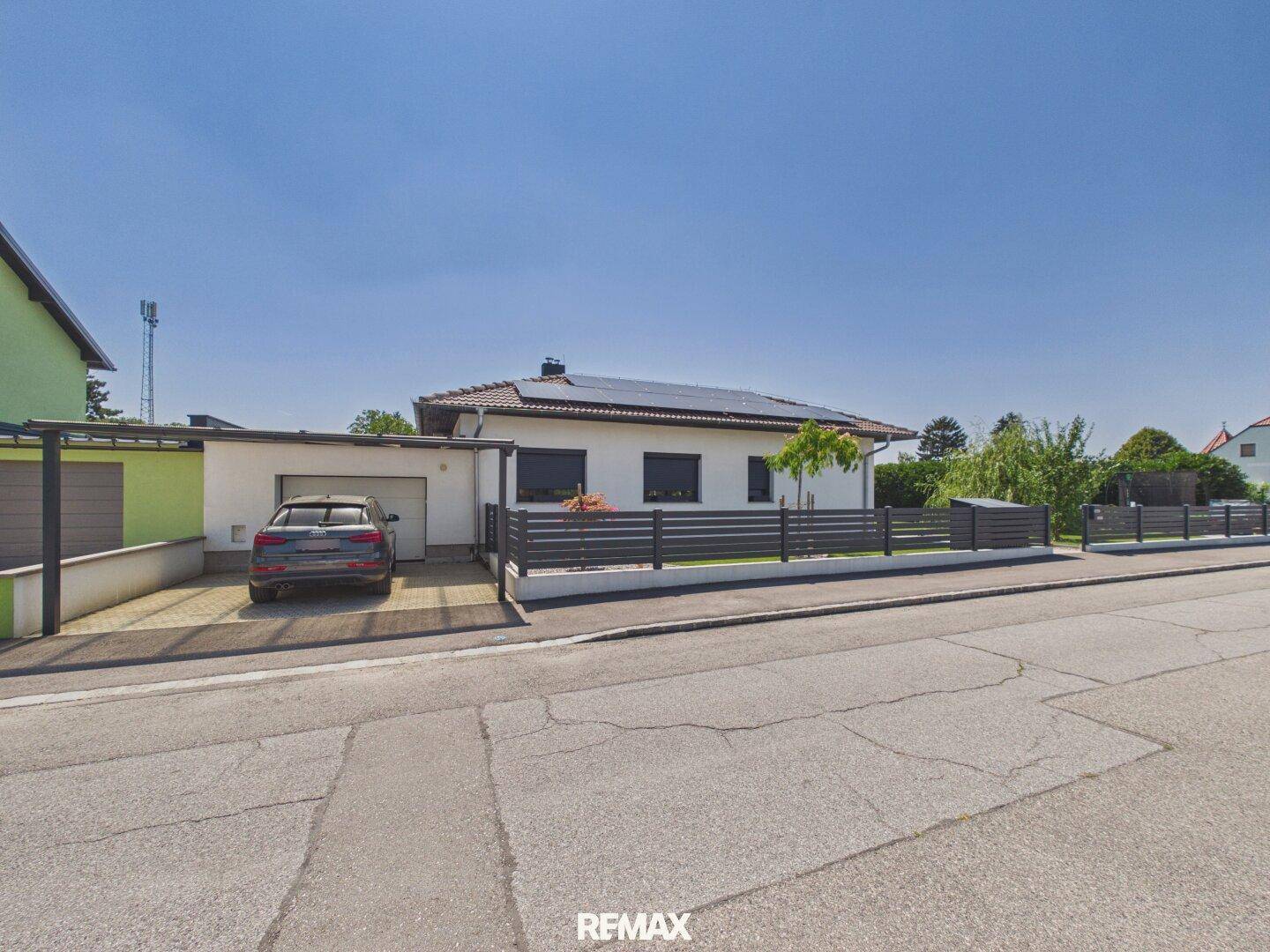 Vorderansicht des Hauses mit Garage, Carport und gepflegtem Vorgarten von der Straße aus.