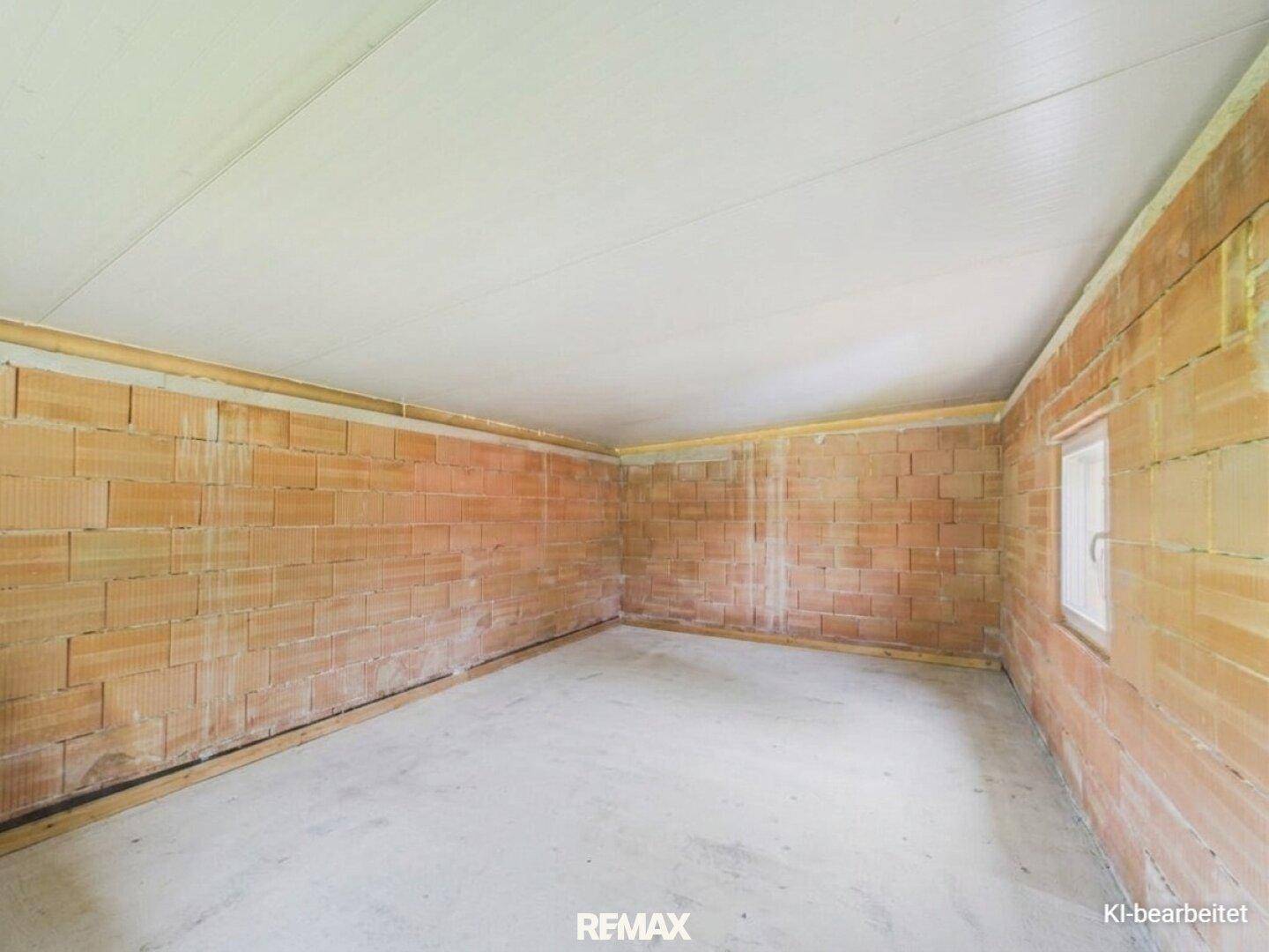 Unfertiger Raum mit Ziegelwänden und Betonboden, bereit für den Ausbau.