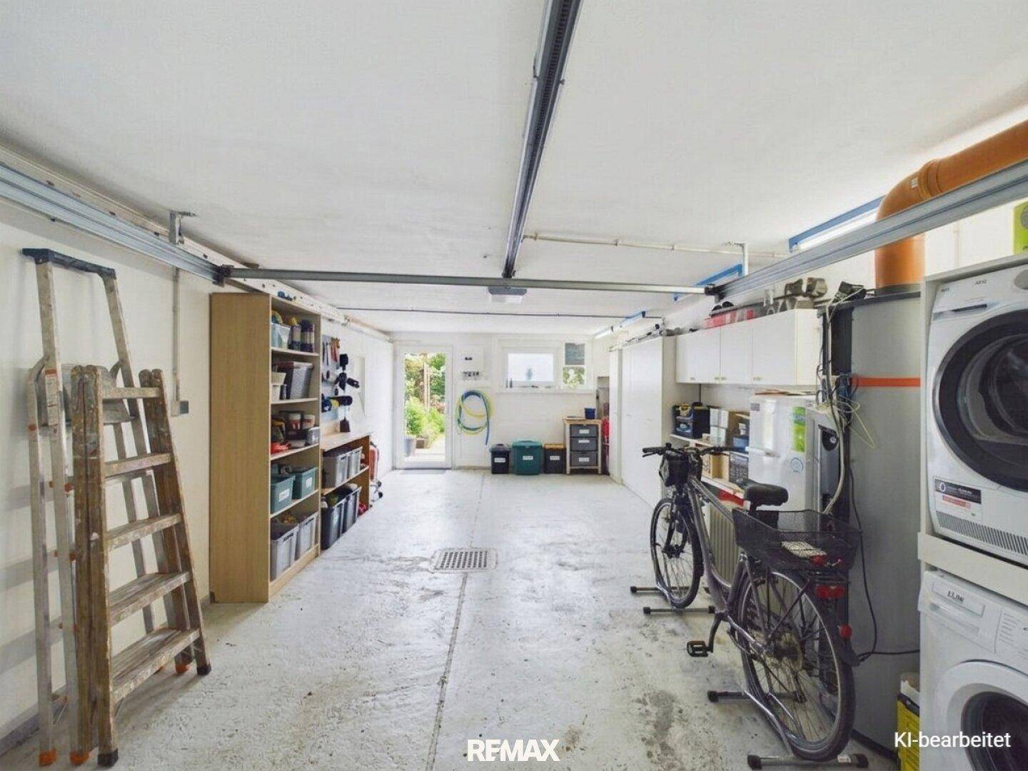 Garage als Mehrzweckraum mit Waschmaschine, Trockner, Fahrrädern und Regalen.