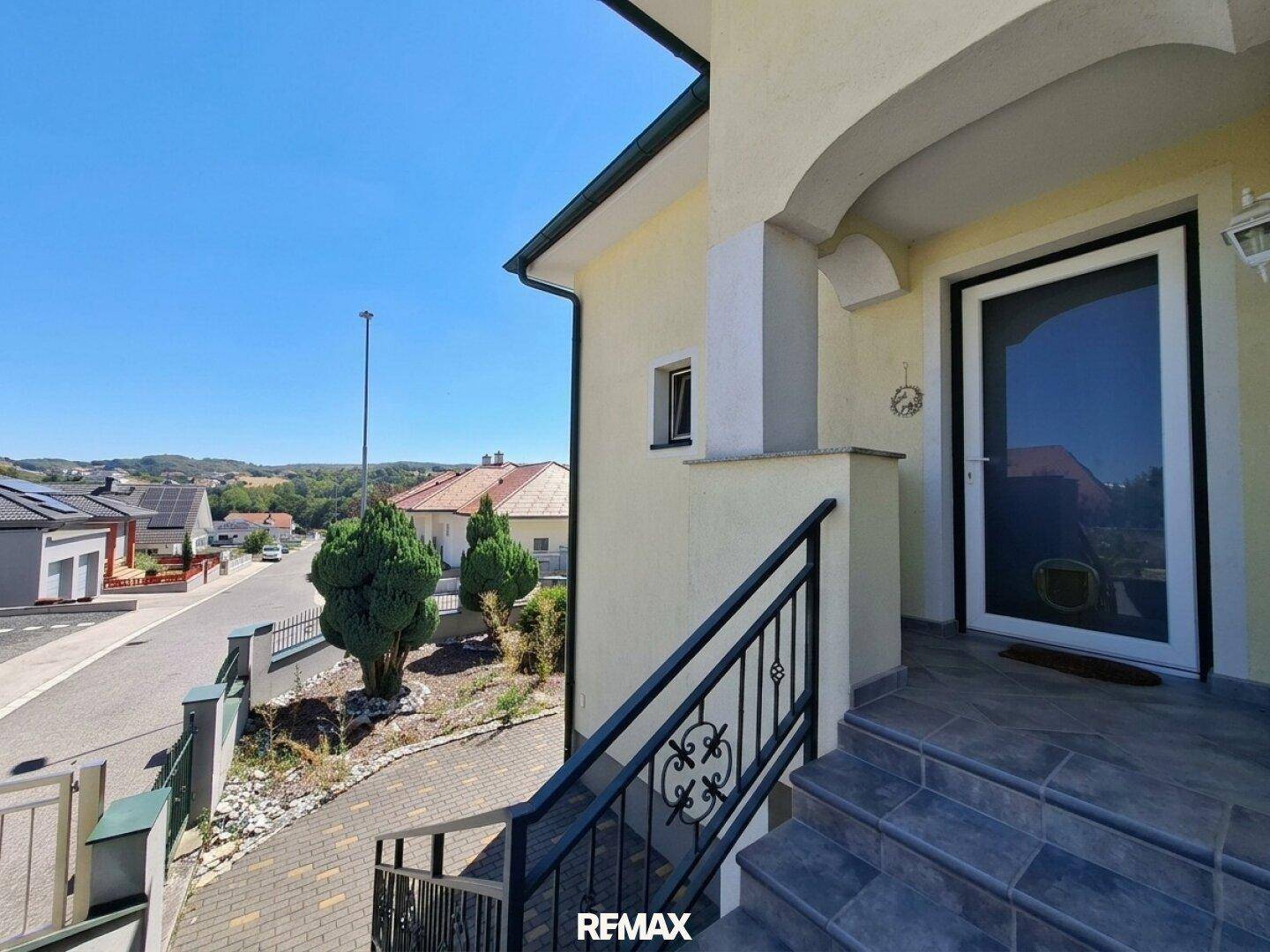 Eingangsbereich des Hauses mit Treppe und Blick auf die ruhige Wohnstraße und Umgebung.