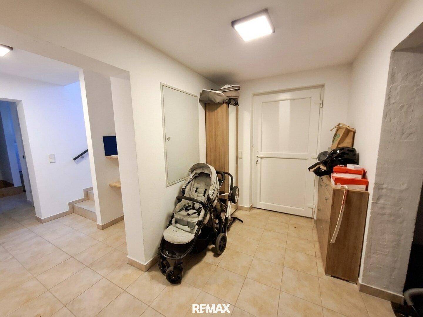 Heller Eingangsbereich mit Fliesenboden und Zugang zur Treppe, ideal für Familien.