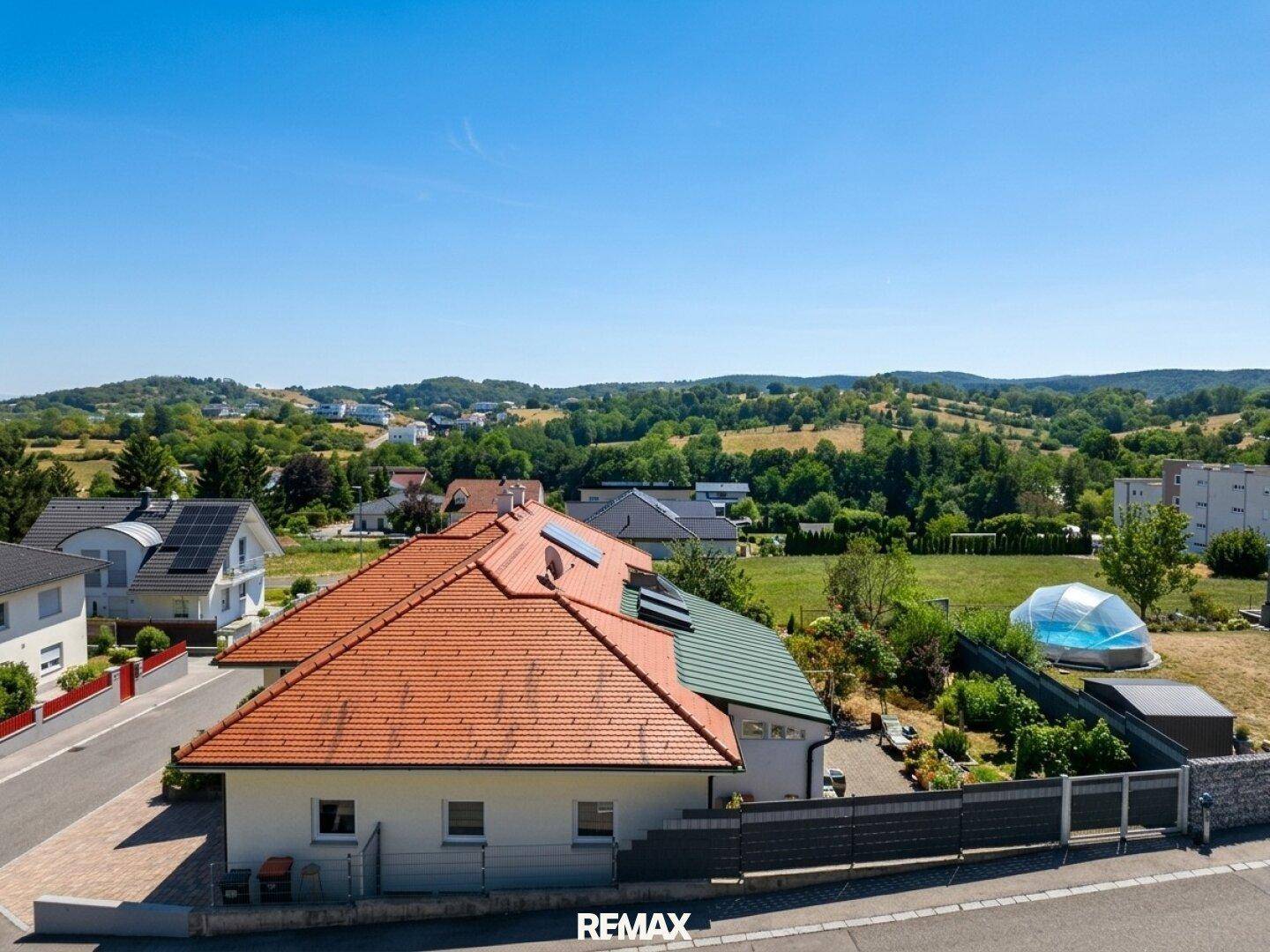 Luftaufnahme eines Hauses mit Ziegeldach, Solaranlage und weitem Blick über die Landschaft.