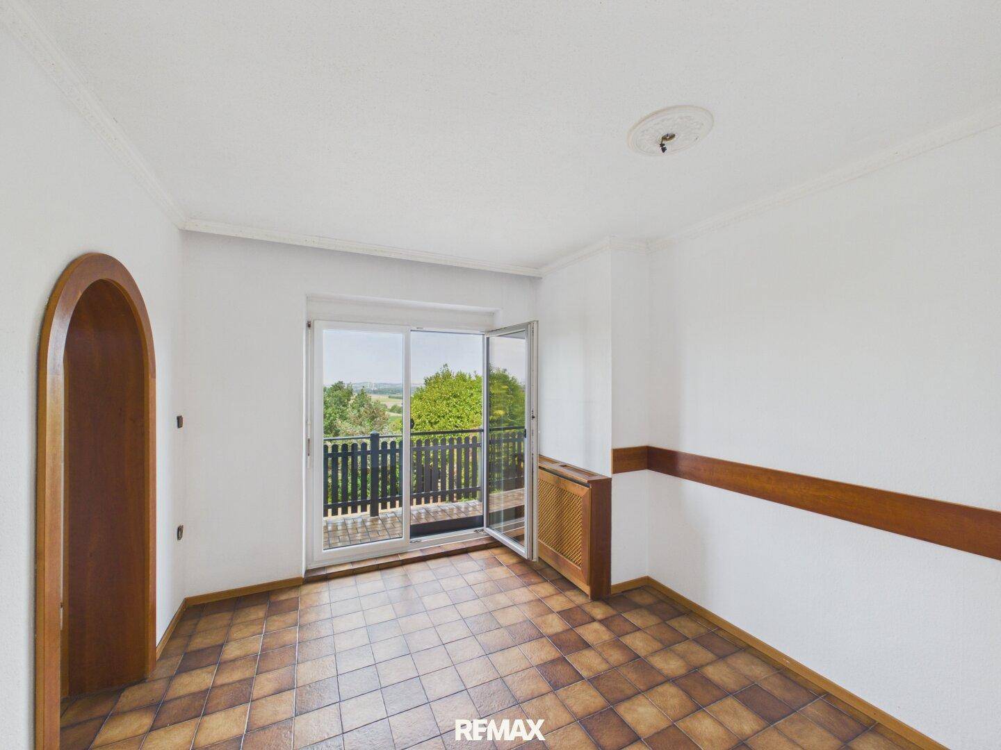 Esszimmer mit Fliesenboden und Zugang zu einem Balkon mit Weitblick.