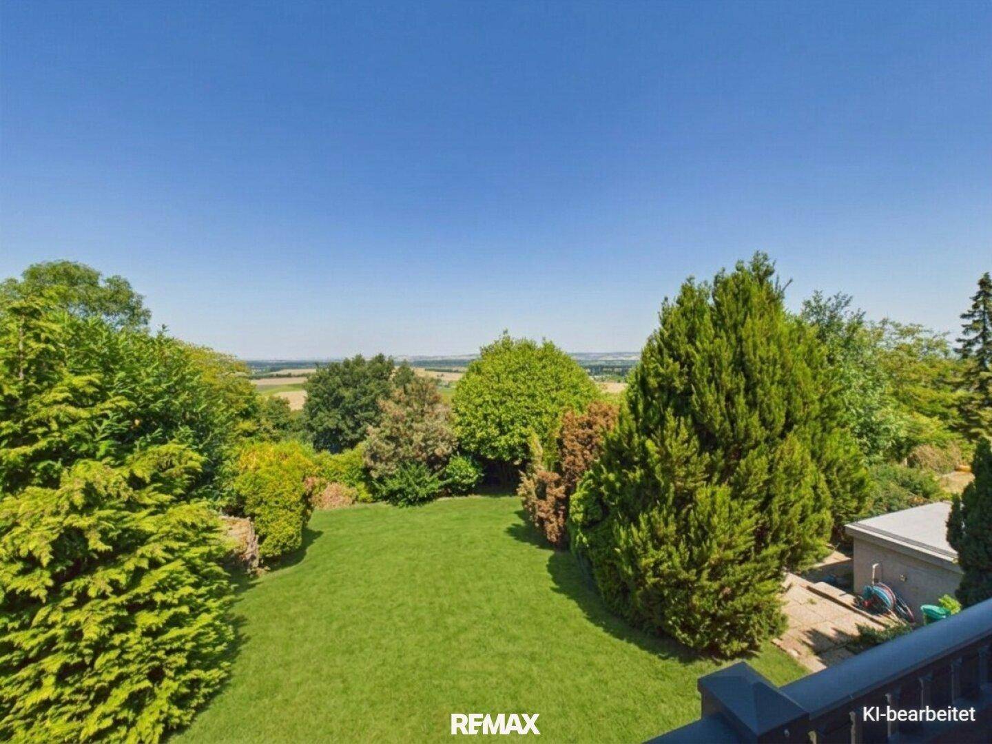 Großer, gepflegter Garten mit Rasenfläche und vielfältiger Bepflanzung unter blauem Himmel.