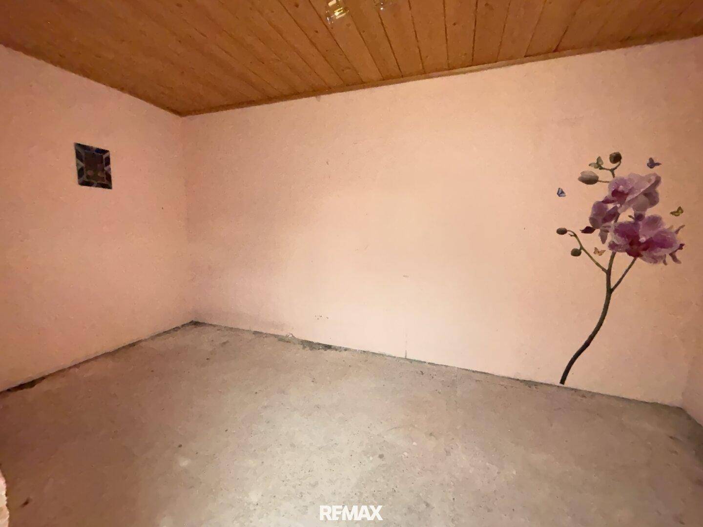 Kleiner Raum mit Holzdecke und einer Orchideen-Wanddekoration.