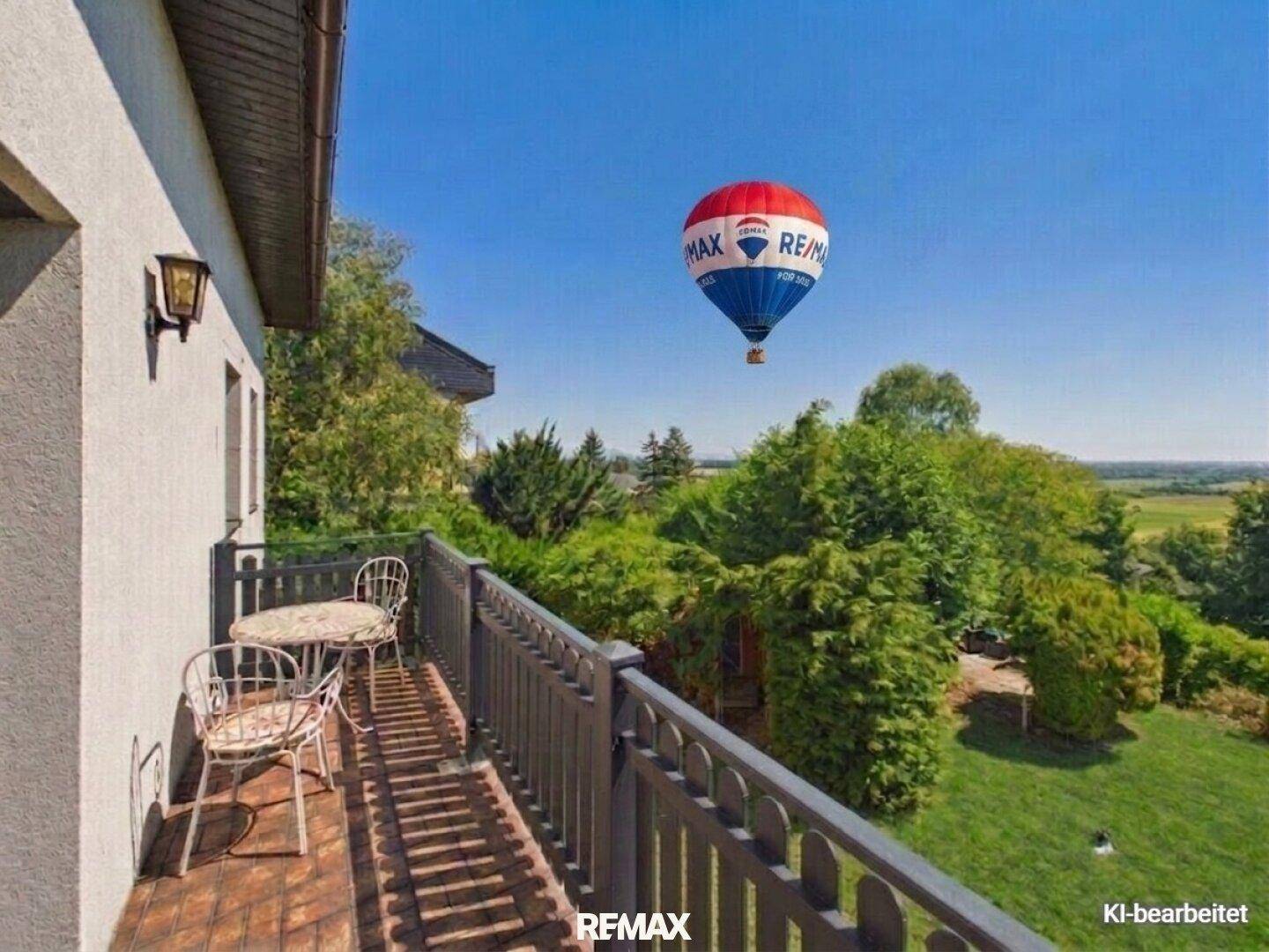 Gemütlicher Balkon mit Sitzgelegenheiten und weitem Blick über die grüne Landschaft und den Garten.