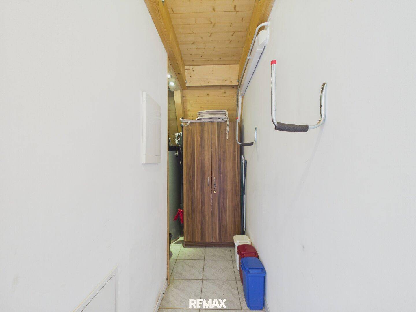 Schmaler Abstellraum mit Schrank und Haken, ideal für Lagerung.
