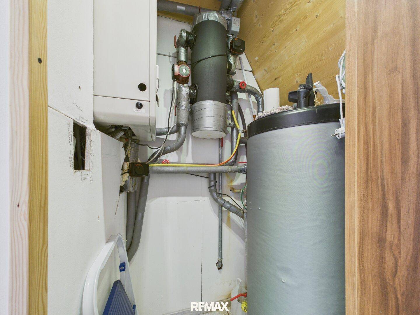 Technikraum mit Heizungsanlage und Warmwasserspeicher, gut zugänglich.