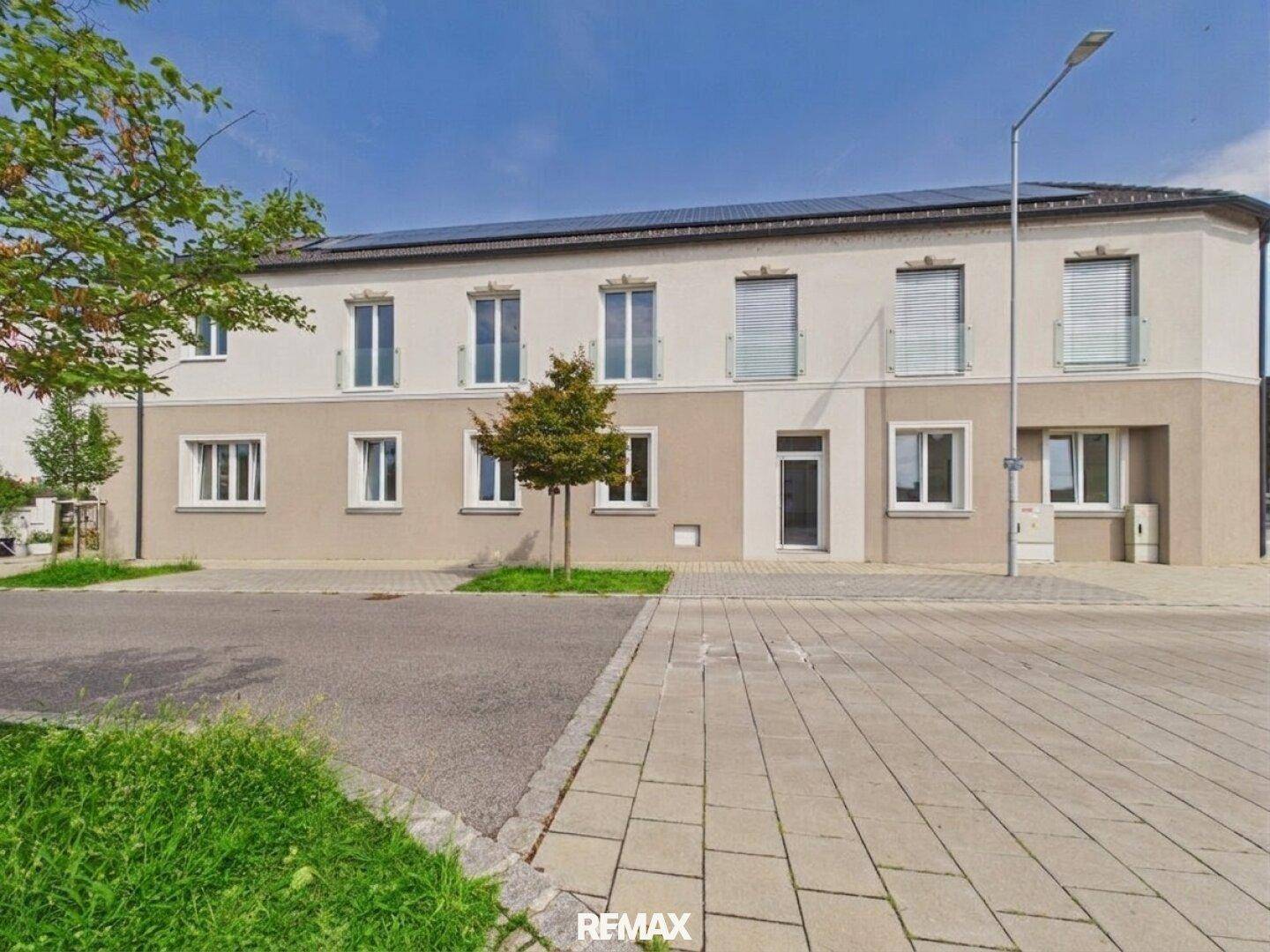 Moderne Wohnanlage mit mehreren Einheiten und Photovoltaikanlage auf dem Dach.