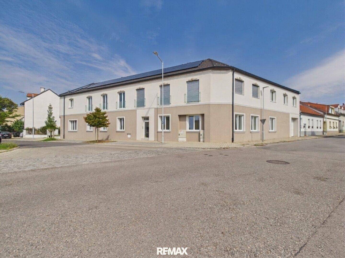 Ansicht des modernen Wohngebäudes von der Straße mit klarem Himmel.